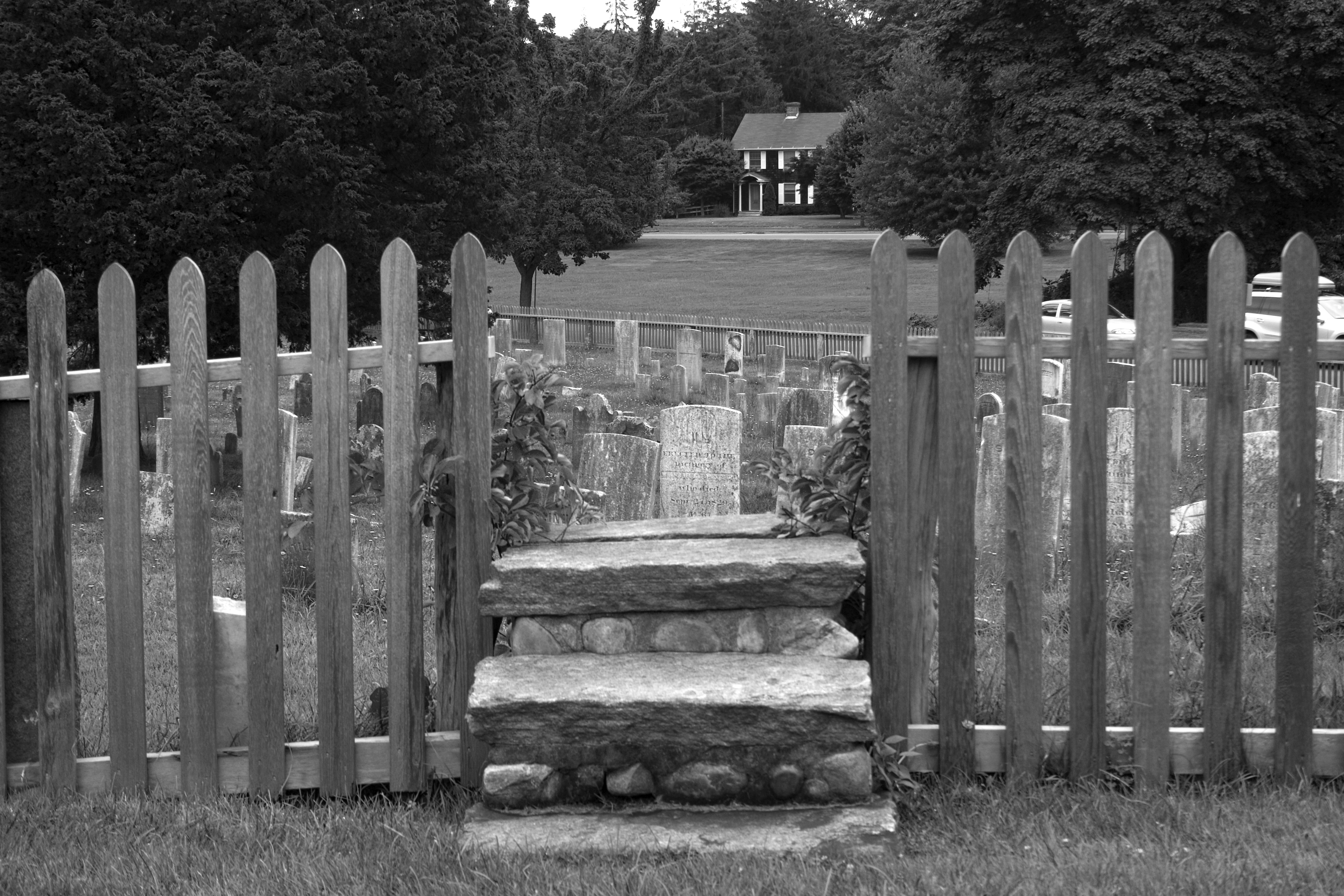 a black and white picket fence around a cemetary